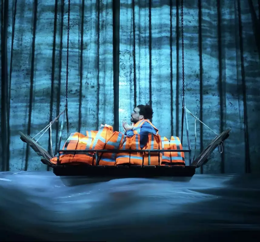 A person on stage in a boat with lifejackets