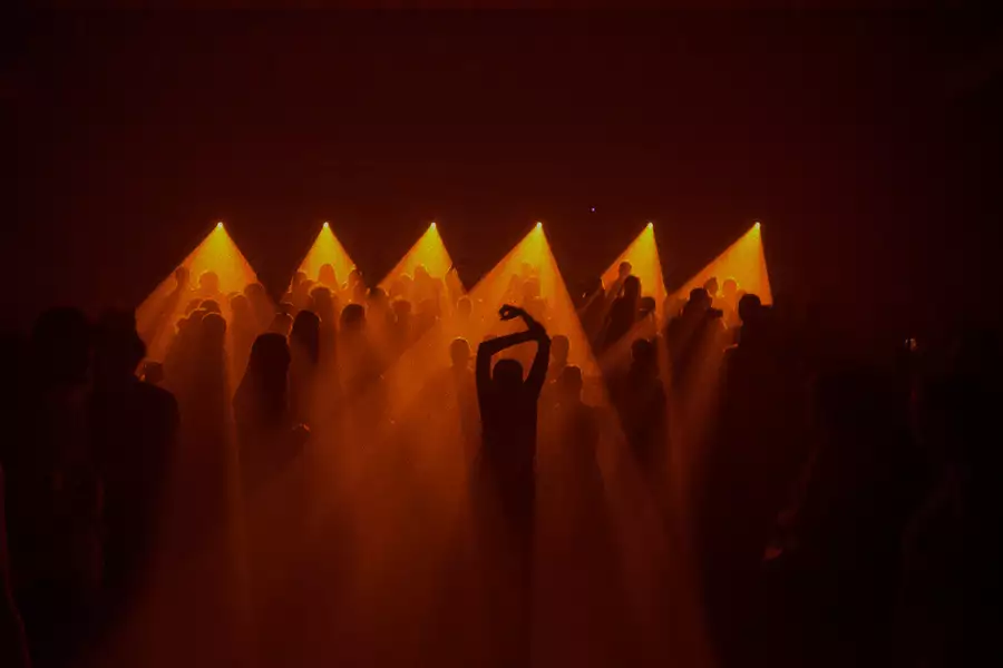 A crowd of people dancing in a low lit room