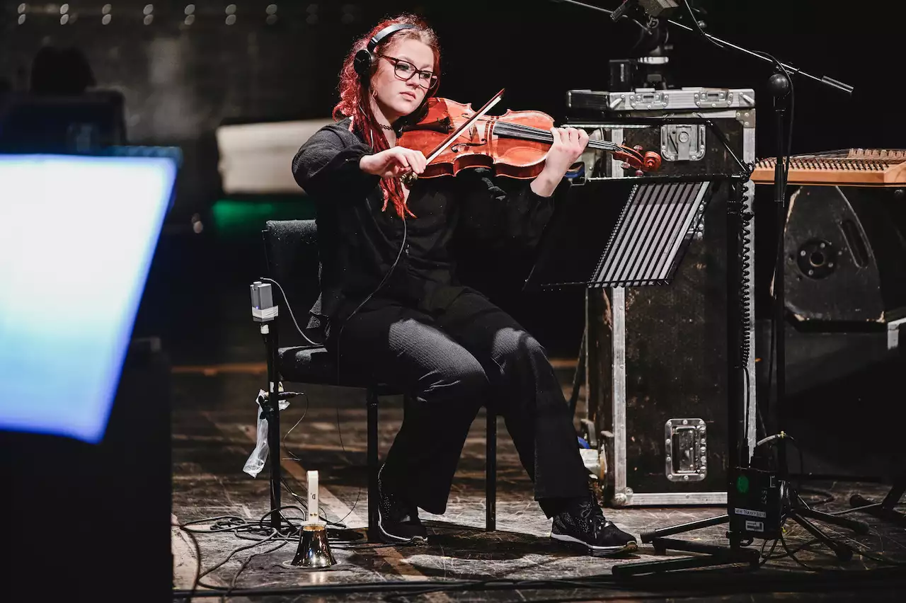 An orchestra member playing a viola