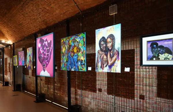 A photograph of the exhibition in the Sim tunnel, showing paintings hung on the wall of a tunnel