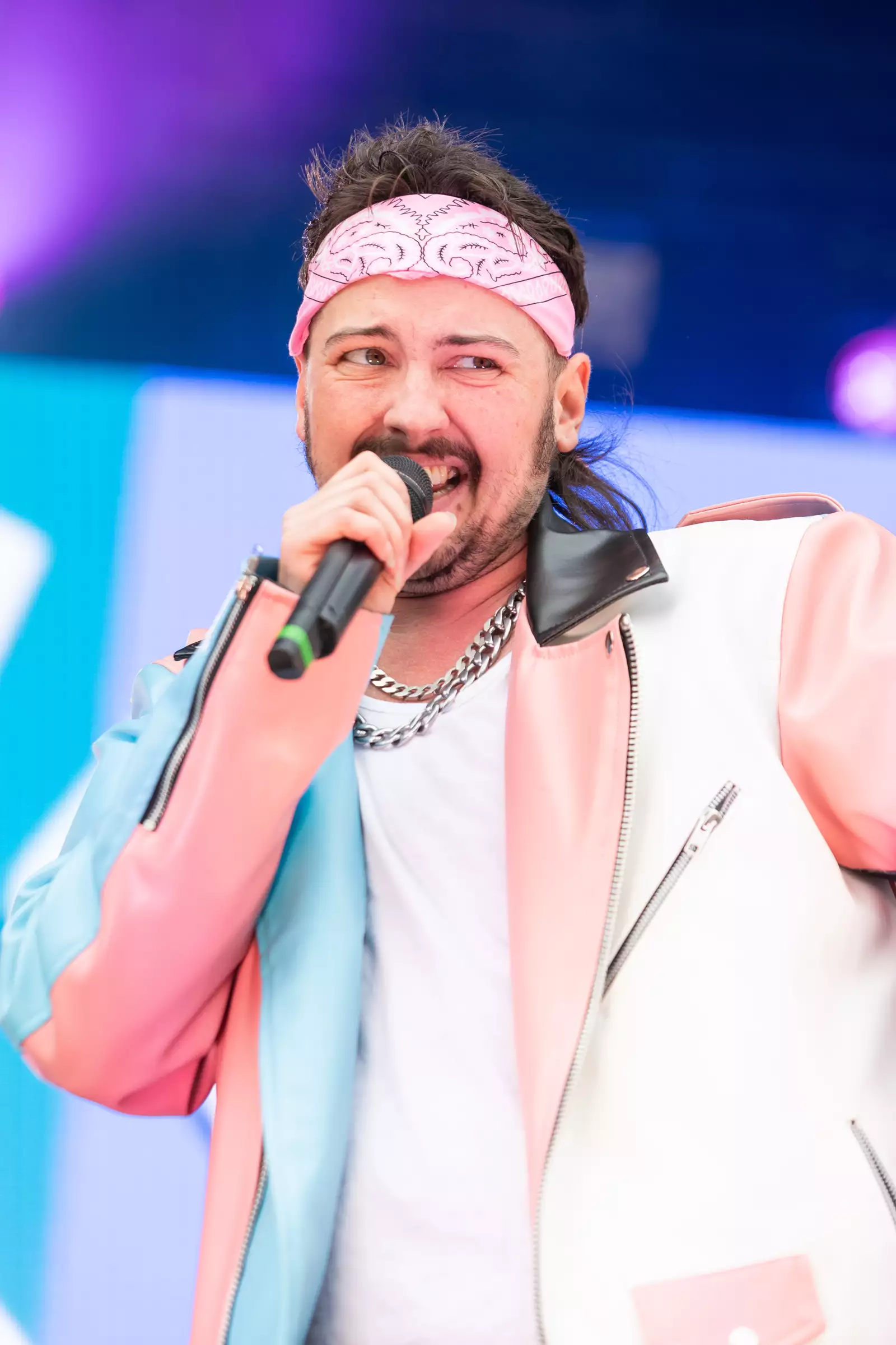 Photo of Wolfy from Canal St Kings talking into a microphone on stage