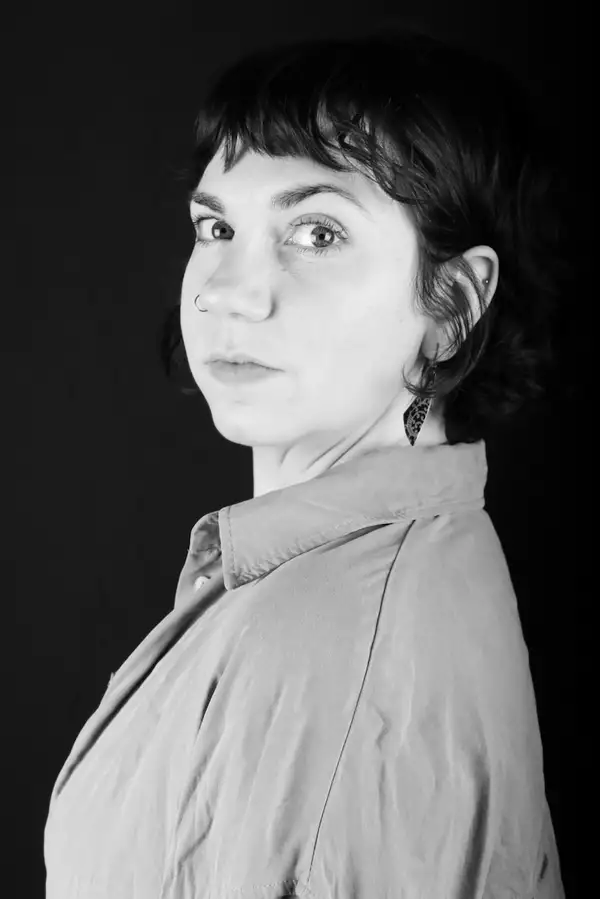 Black and white headshot of Nina Murphy, wearing a shirt and looking to the side