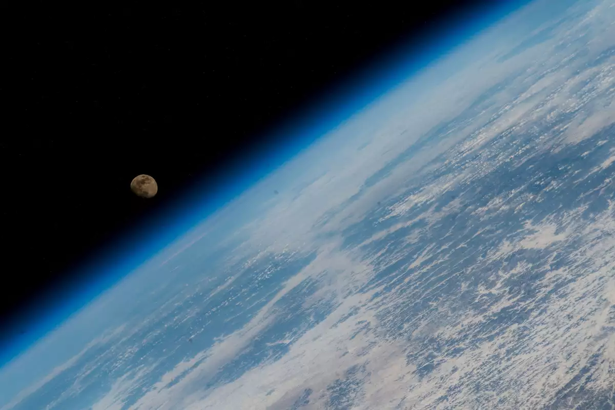A photograph of the Moon rising over Earth's horizon