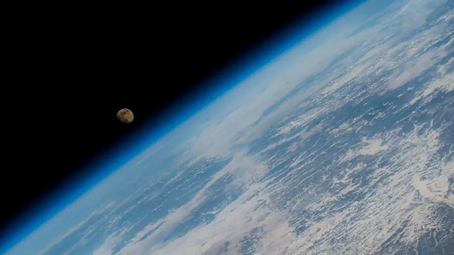 A photograph of the Moon rising over Earth's horizon