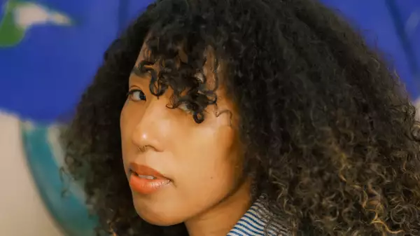 Close-up photo of ALYA L on a blue background