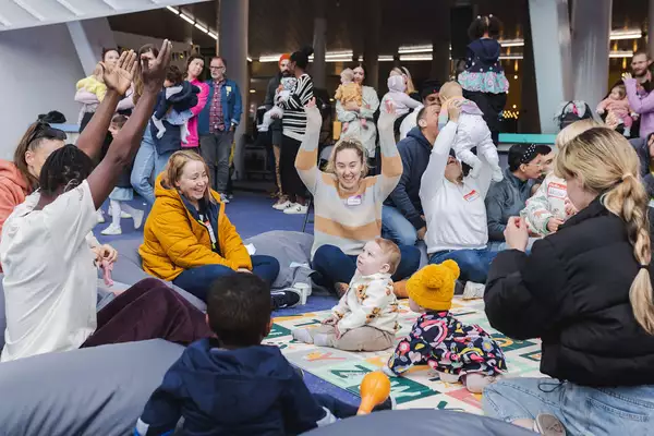 Parents/carers playing with babies outside Aviva Studios