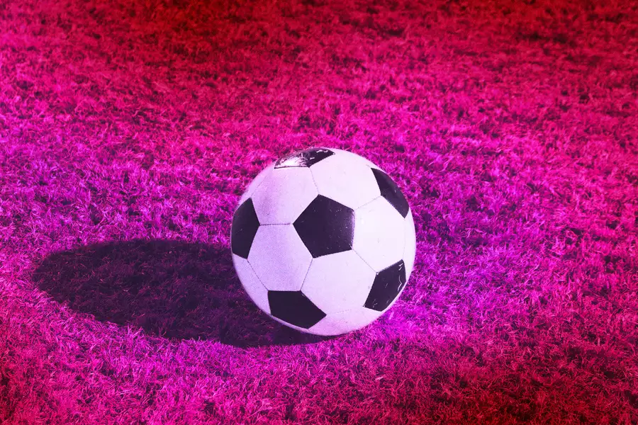 A football on a bright pink football pitch