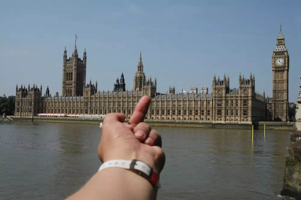 Photograph of Ai Weiwei putting his middle finger up to the Houses of Parliament