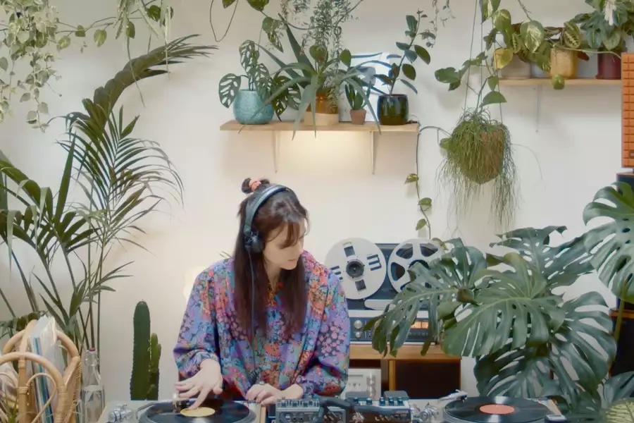 Photo of Lena C DJing surrounded by plants