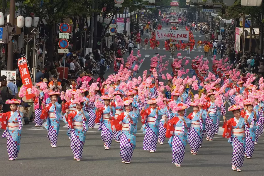 A parade of people dressed in bright, traditional Japanese dress