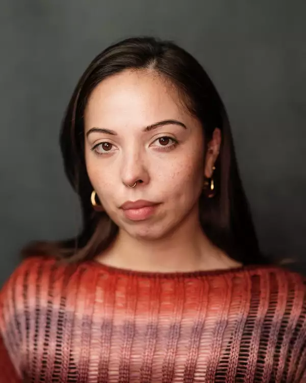 Headshot of Marienella Phillips wearing an orange and purple knitted jumper