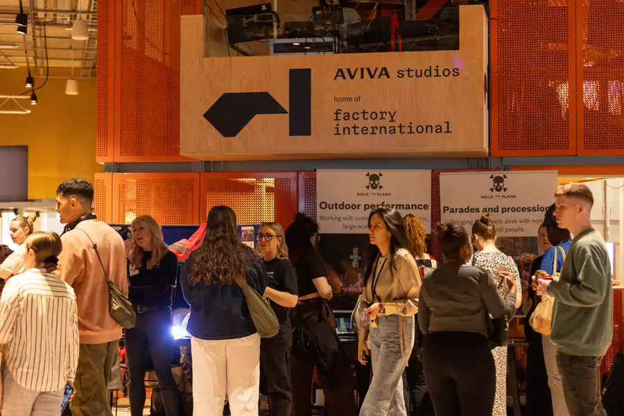 Photo of a crowd of people stood in front of the orange box in the Social chatting, moving and smiling