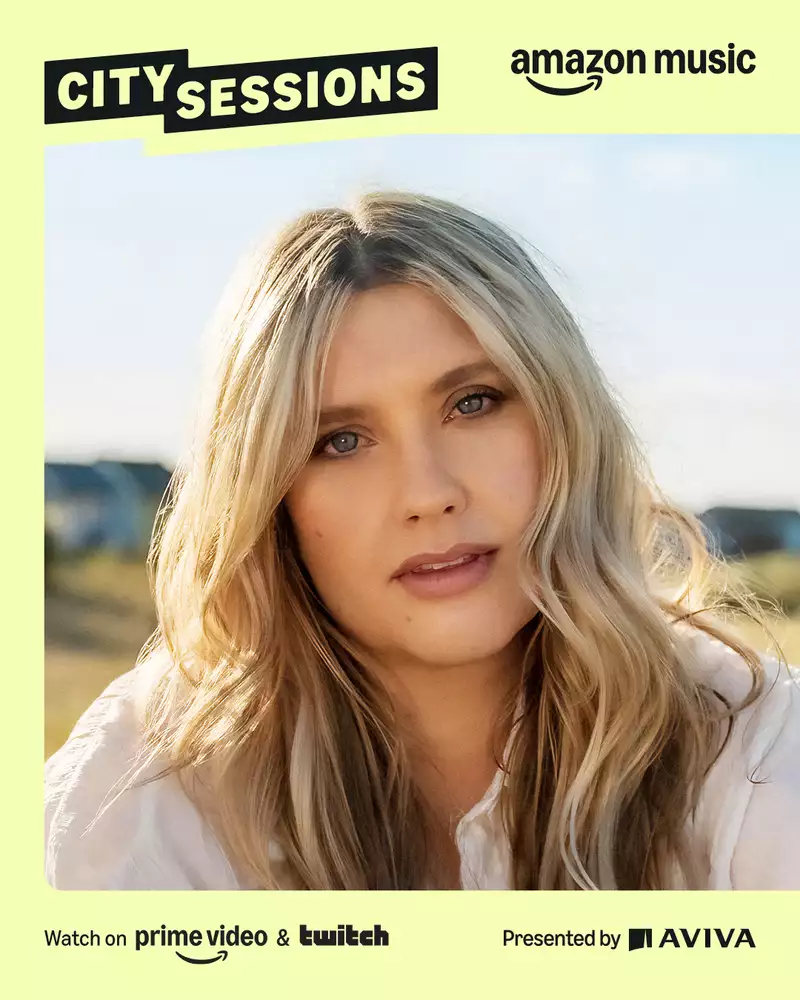 A promotional photograph of the singer Ella Henderson with Amazon and Aviva branding on a yellow background