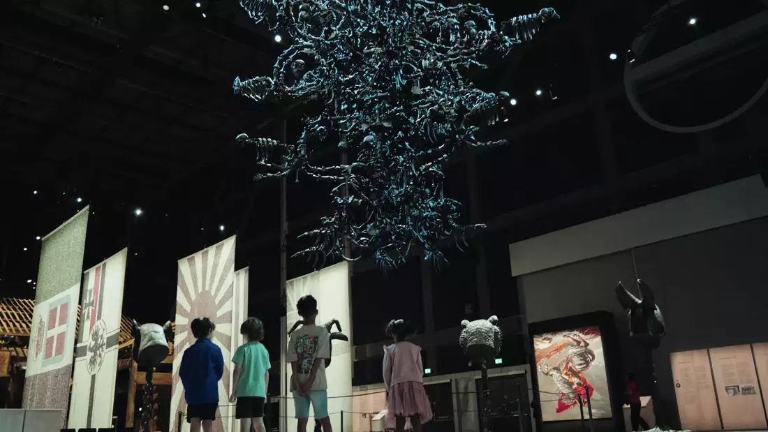 A group of children look at Ai Weiwei's artwork La Commedia Umana in Ai Weiwei: Button Up!