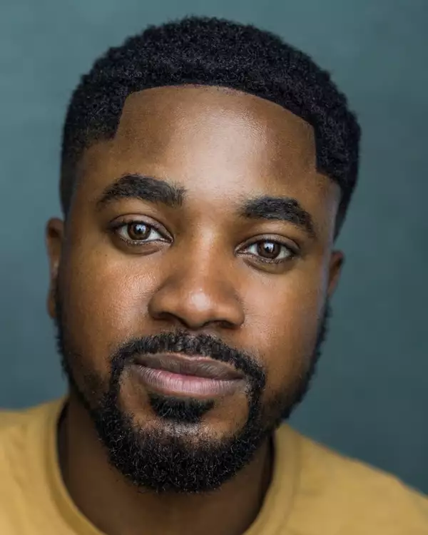Headshot of Daniel Davids wearing a mustard yellow t-shirt