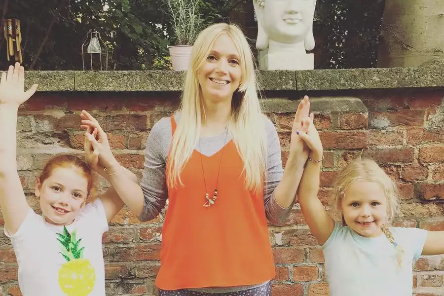 Photo of an adult and two kids practising yoga