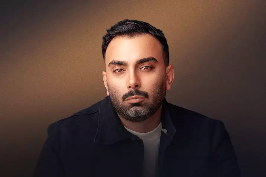 Masoud Sadeghloo wearing a black suit jacket on a black and brown background