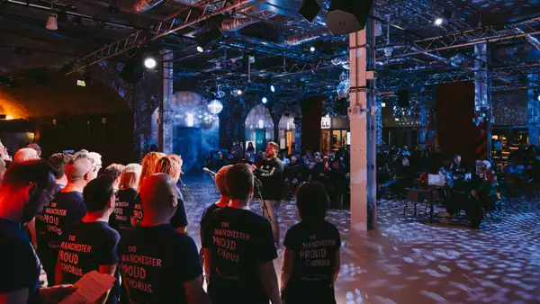 Manchester Proud Chorus performing in the Social with dim lighting and disco balls
