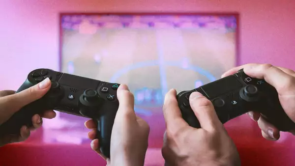 Two consoles in front of a glittery pink screen