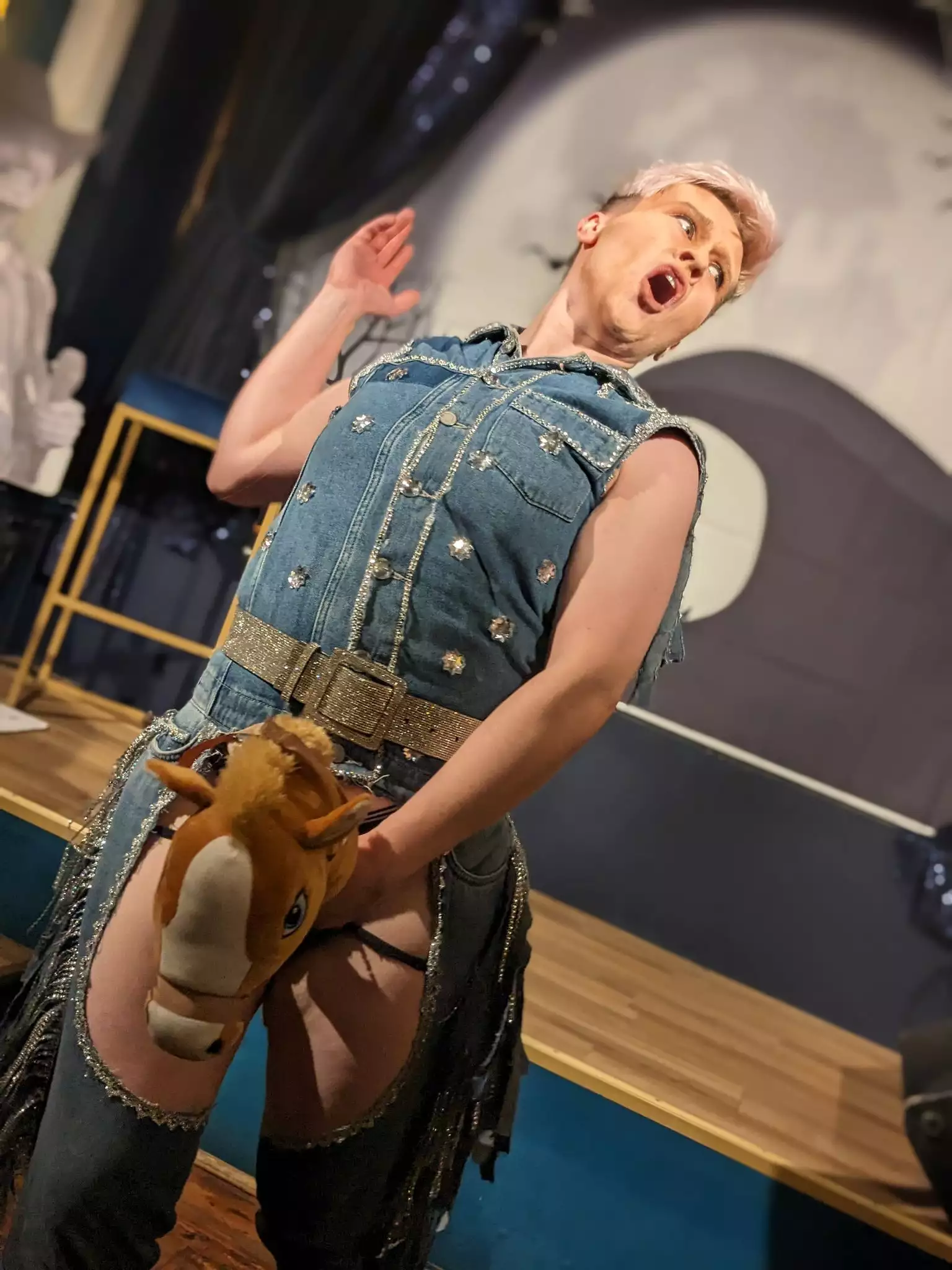 TK Maxximus performing on stage with a toy horse