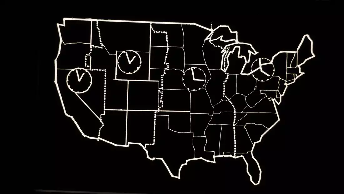 Black and white still from Laurie Anderson's United States Parts 1–4, showing the outline of the USA with four clocks inside