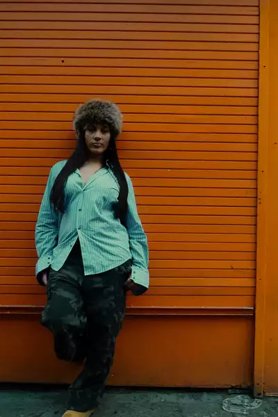 Mya Lashantai stood in front of an orange wall