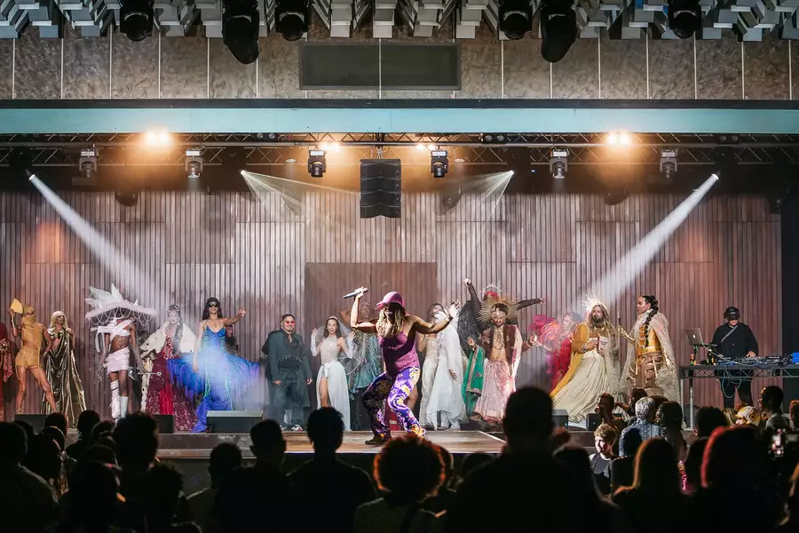 A large crowd of people watching a pageant on stage