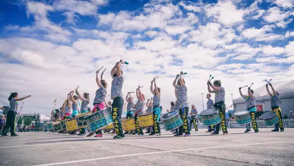 Drummers performing outside on a sunny day
