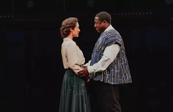 Two actors on stage during Liberation holding each other