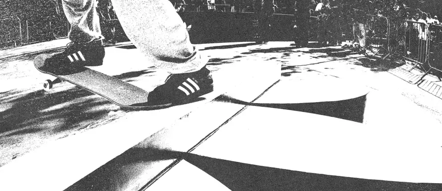 Black and white image of someone skateboarding on an Adidas skate ramp wearing Adidas trainers