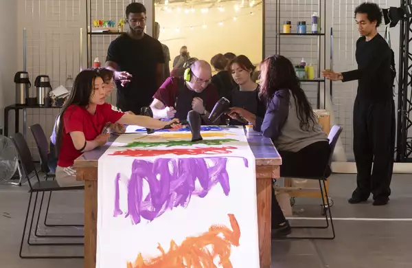 Michael Beard working on an artwork with a group of people during his residency at MIF23