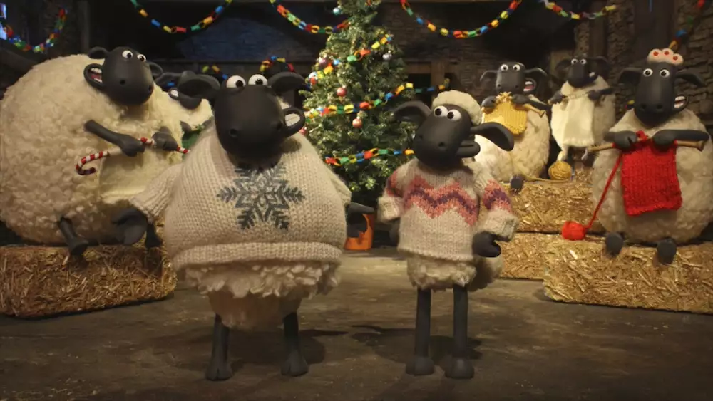 Shaun the Sheep and his Flock wearing knitted fleeces in front of a Christmas tree