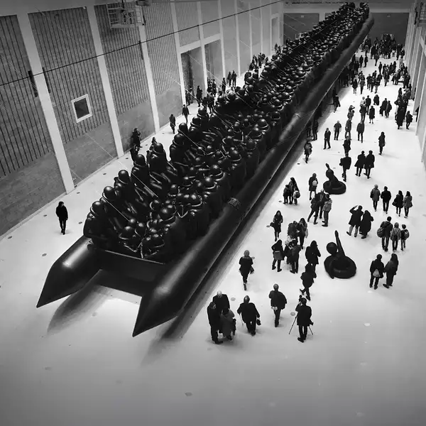 Ai Weiwei's Law of the Journey artwork, showing a crowd of people surrounding a huge, inflatable migrant boat in a big warehouse