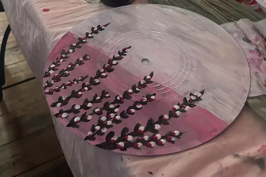 A record painted pink and purple with flowers on