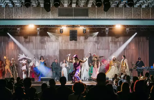 A large crowd of people watching a pageant on stage
