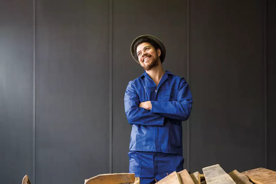 Photographic portrait of Kemang wa Lehulere stood behind planks of wood