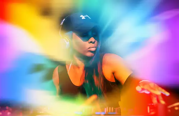 DJ Sequinella with a rainbow background