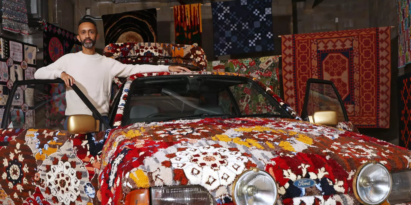 Hetain Patel stood by an artwork, which is a brightly patterned car