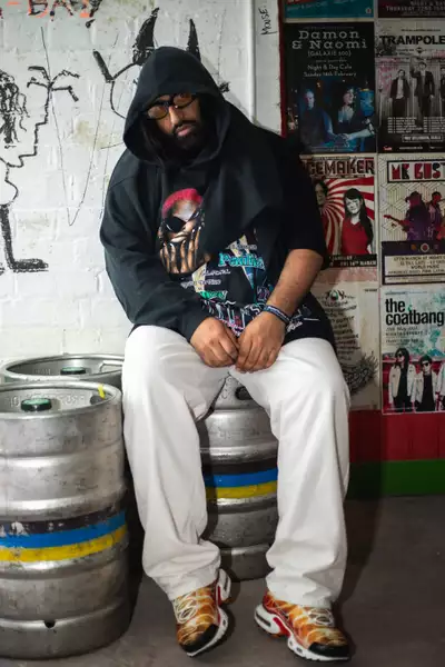 DJ KAM sat on beer casks in a club