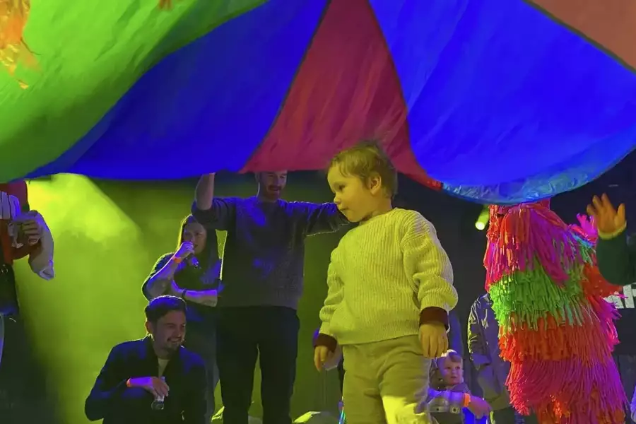 Children playing under a colourful parachute