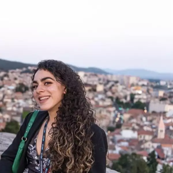 Photograph of Ruby Ramelize smiling at a viewpoint above a city