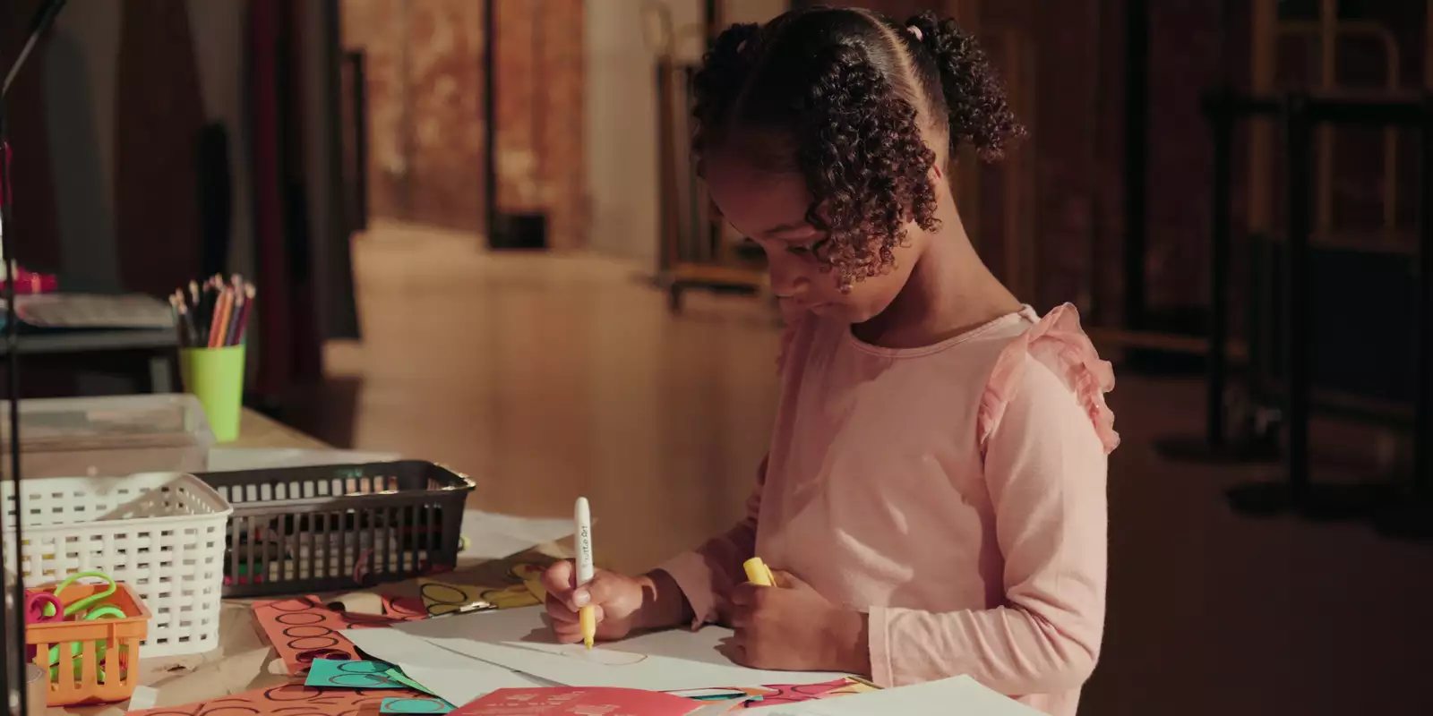 A child colouring in at a table in the Social