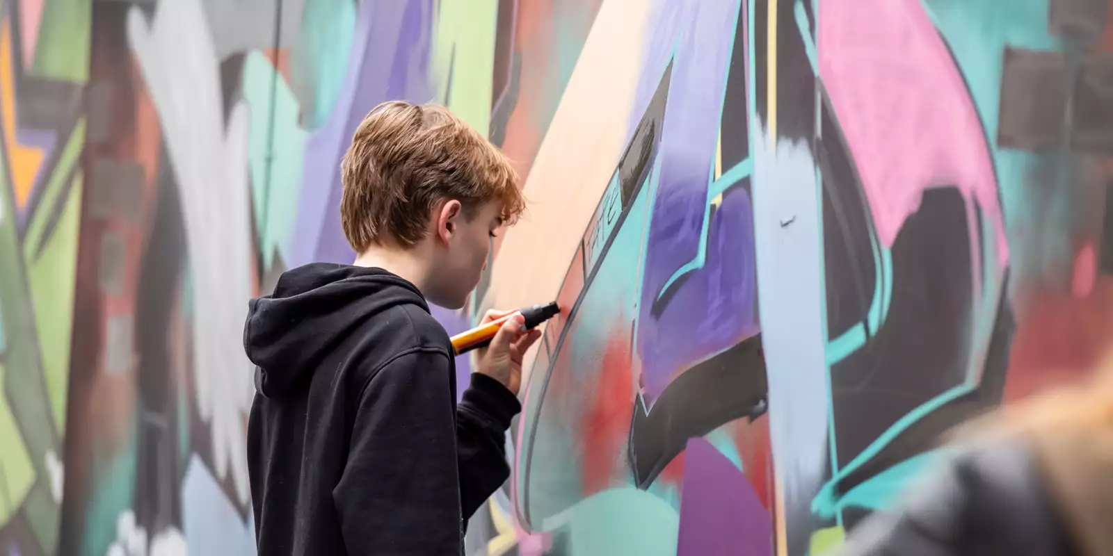 A person looks at a graffiti wall at the Street Culture Takeover event at the Welcome at Aviva Studios