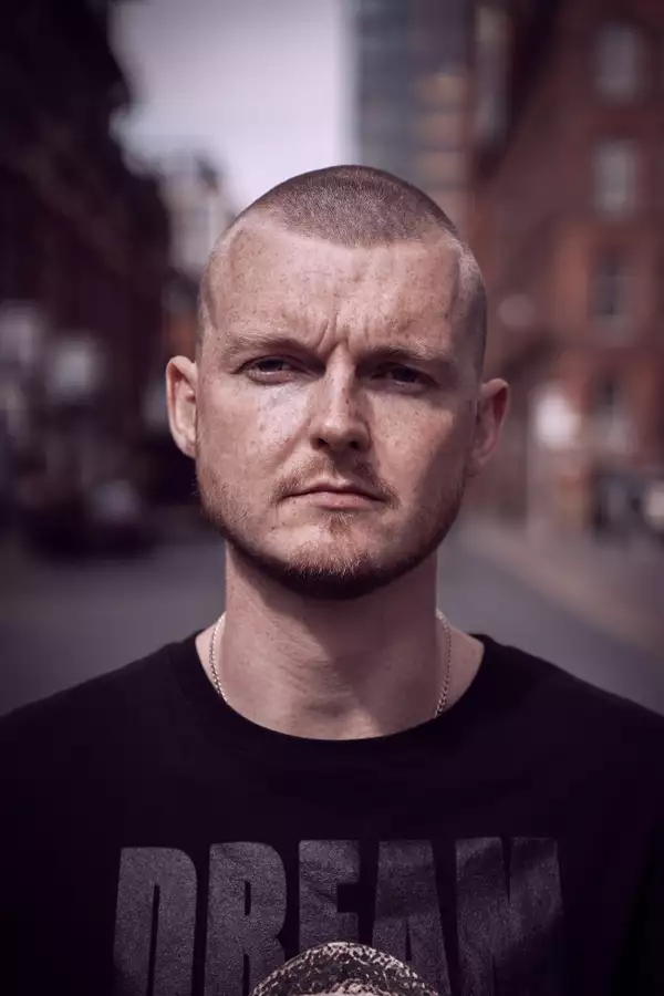 Dancer Mark Boyce wearing a black t-shirt and neck chain