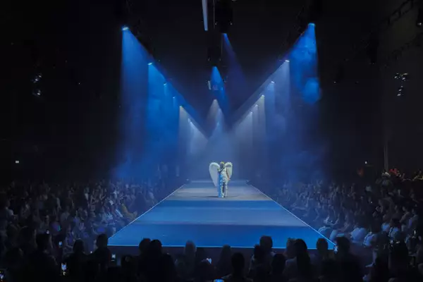 A performer on the runway with a huge crowd in the Warehouse during House of MCR