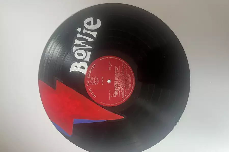 A vinyl painted with Bowie's iconic logo onto it.