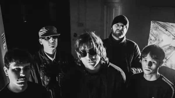 Black and white photo of five members of ROLLA staring at the camera. Two are wearing sunglasses.