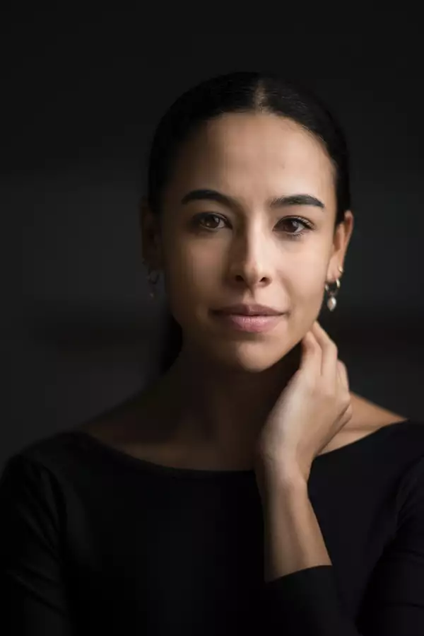 Headshot of Winnie Dias, who is touching her neck
