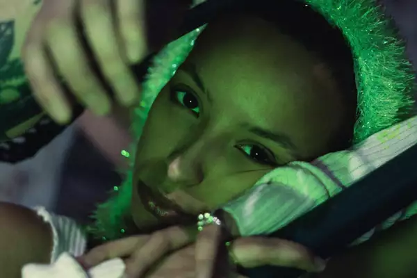 A green light shines on singer Karis Jade