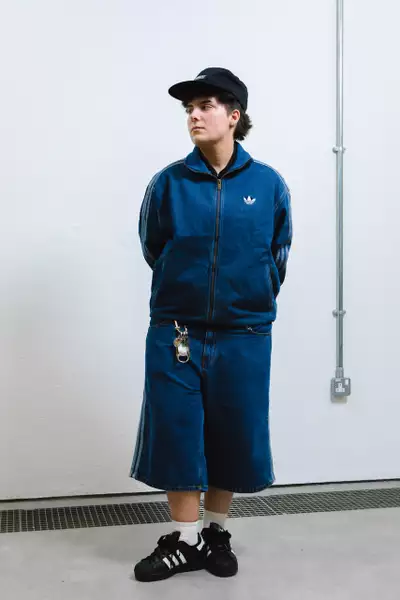 Anna Pugh wearing a denim Adidas jacket and shorts with trainers